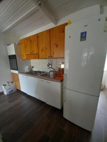 泰拉奇纳Casa tiziana的厨房配有白色冰箱和木制橱柜。