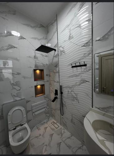 Sayqاستراحة رافلز的白色的浴室设有卫生间和水槽。