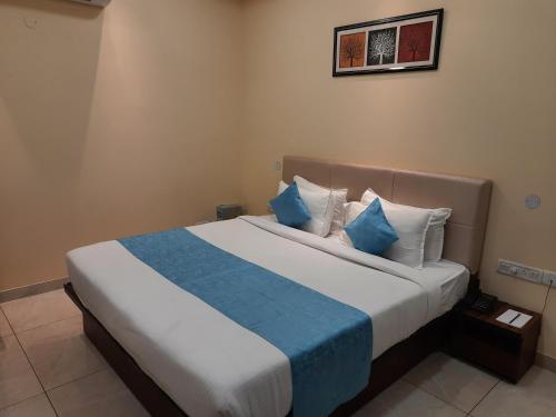 Paliā KalānClarks Inn Dudhwa的一间卧室配有一张带蓝白色枕头的大床