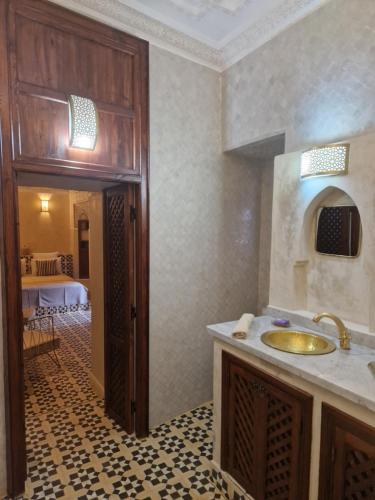 马拉喀什里亚德马拉喀什之夜酒店的一间带水槽的浴室和一间带桌子的房间