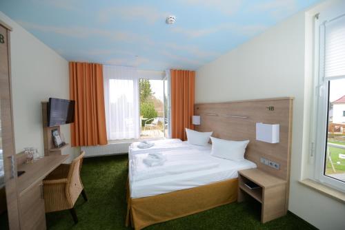 GrünbachDer Bayerische Hof的酒店客房设有一张床、一张书桌和窗户。