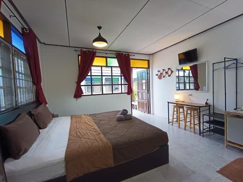 奈扬海滩THE NAIYANGHOUSE的卧室配有一张床、一张书桌和窗户。
