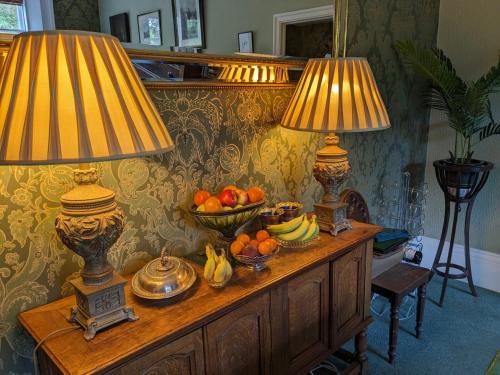 达多山墙奢华住宿加早餐旅馆的一张桌子,上面有两盏灯和一碗水果