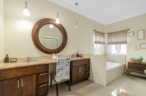 拿骚Blu Diamond Luxury Estate的浴室配有盥洗盆、镜子和浴缸