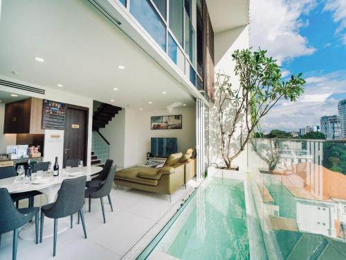 胡志明市Serenity Saigon Sky Villas的用餐室和带游泳池的客厅