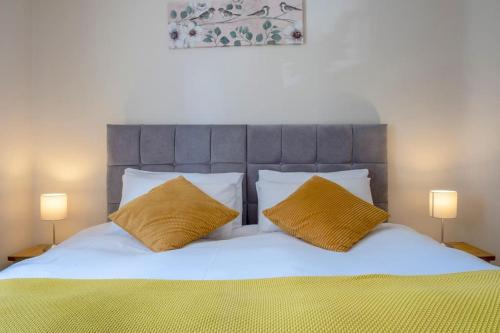 BarrasfordCosy Northumbrian Cottage的一间卧室配有一张带两个黄色枕头的床