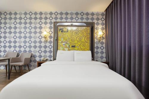 坡州市Carlton Hotel的一间带白色床的卧室和一间用餐室