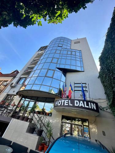 布加勒斯特Darin Hotel的上面标有酒店要求标牌的酒店大楼