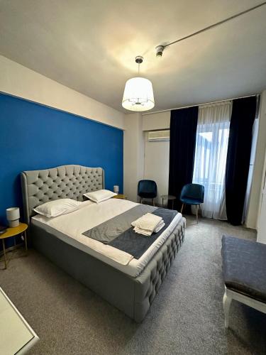 布加勒斯特Darin Hotel的一间卧室设有一张蓝色墙壁的大床