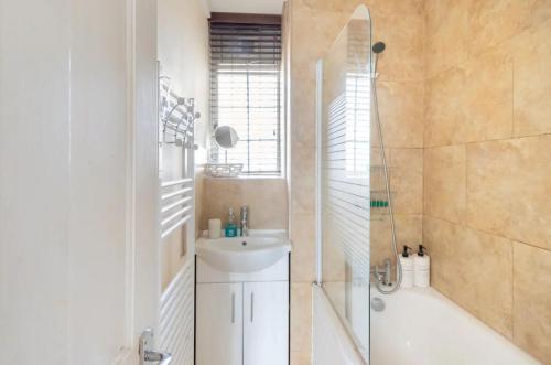 伦敦Stunning 1 bed flat in the heart of Greenwich的带淋浴、盥洗盆和浴缸的浴室