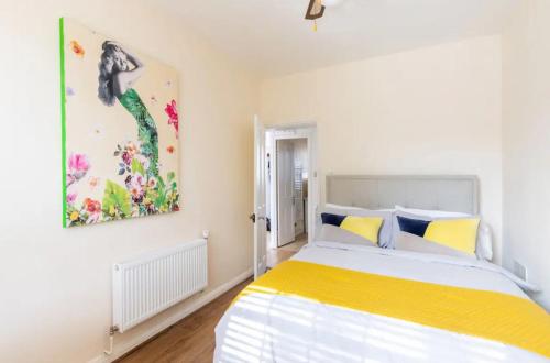 伦敦Stunning 1 bed flat in the heart of Greenwich的卧室配有一张床,墙上挂有绘画作品