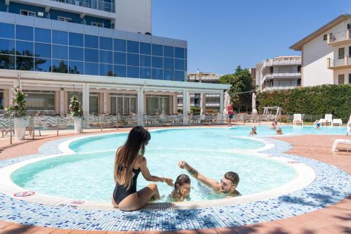 锡尔维玛丽娜Hermitage Hotel的家庭在游泳池玩耍