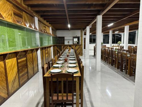 伊塔佩马Vila dos pássaros, Quarto 02的一间长长的用餐室,配有一张带盘子的长桌