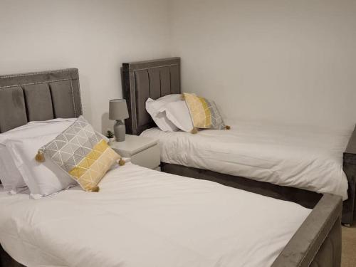伊普斯威奇Modern 2bedroom House in Ipswich Suffolk的卧室内两张并排的床