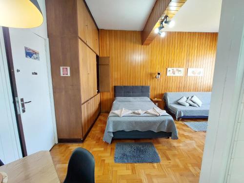 特雷索波利斯Estúdio 427 Teresópolis的一间带两张床铺的卧室,位于带木墙的房间内