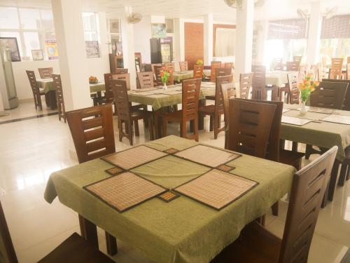 卡特勒格默Visaka Hotel - Kataragama的餐厅配有桌椅和绿色桌布