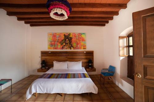 瓦哈卡市NaNa Vida Hotel Oaxaca的一间卧室配有一张带木制床头板的床