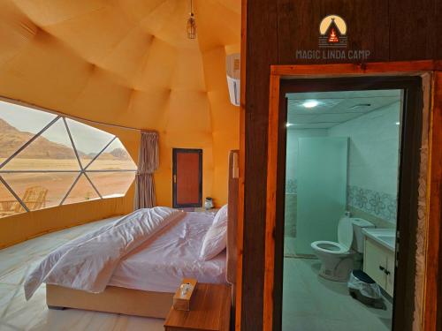 瓦迪拉姆wadi rum,Linda Camp的一间设有床铺的卧室和位于帐篷内的浴室
