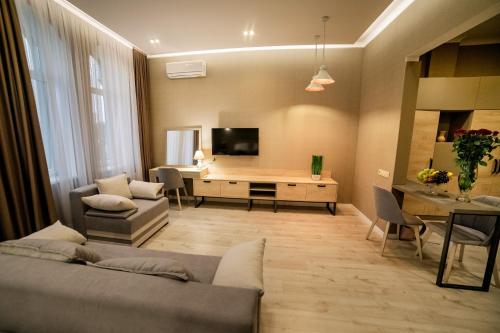 特鲁斯卡韦茨Apart-Hotel CARDINAL的客厅配有沙发和书桌及电视