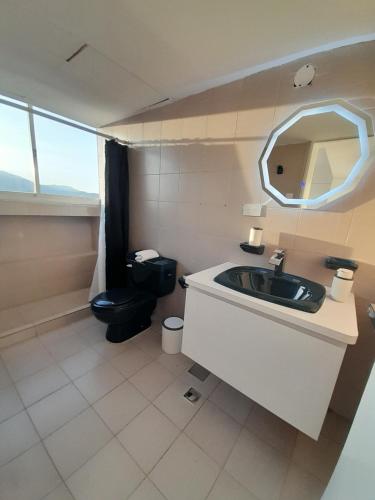 波拉马尔Executive Style Condo With Sea Views的一间带水槽、卫生间和镜子的浴室