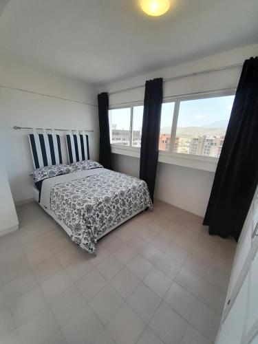 波拉马尔Executive Style Condo With Sea Views的一间卧室设有一张床和一个大窗户