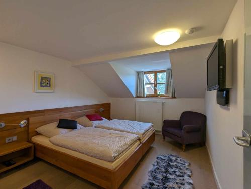 菲利普斯罗伊特Ferienwohnungen Kricklsäge的一间卧室配有一张床、一台电视和一把椅子