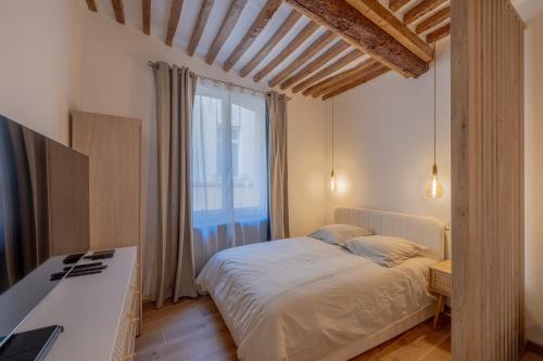 普罗旺斯艾克斯Appartement de charme的一间卧室设有一张床和一个大窗户