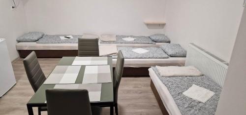 什图罗沃Andrea ubytovanie的一间设有四张床和一张桌子及椅子的房间