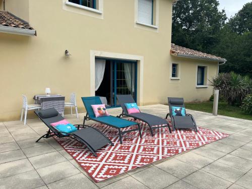 尚塞拉德Maison de vacances avec piscine的坐在庭院地毯上的一组椅子