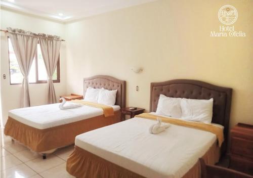 San LuisHotel y Restaurante Maria Ofelia的酒店客房设有两张床和窗户。