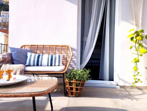 卡利诺岛Ammoudara's apartments Rooftop的阳台的藤椅和咖啡桌