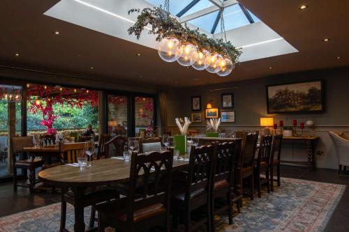 汤布里奇木匠阿姆斯酒店的一间带桌椅和吊灯的用餐室