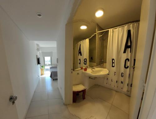 罗萨里奥Monoambiente con cochera en Puerto Norte的浴室设有水槽和按字母顺序排列的浴帘。