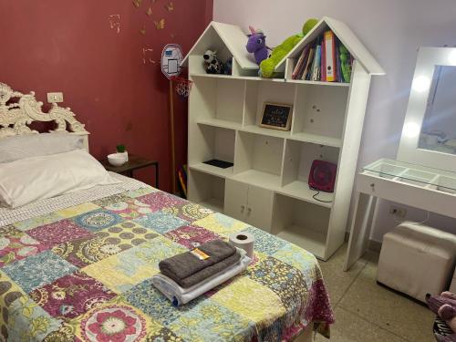 巴兰卡Alójate en una Casa familiar的一间卧室设有一张床和一个书架