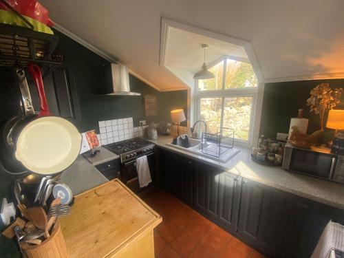 卡迪夫Cardiff - Home from Home的厨房配有黑色橱柜、水槽和窗户。