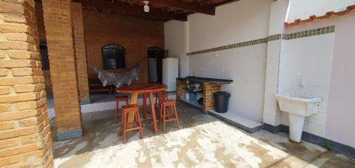 古里里Casa Temporada Guriri Beira-Mar的天井设有2张凳子、水槽和桌子