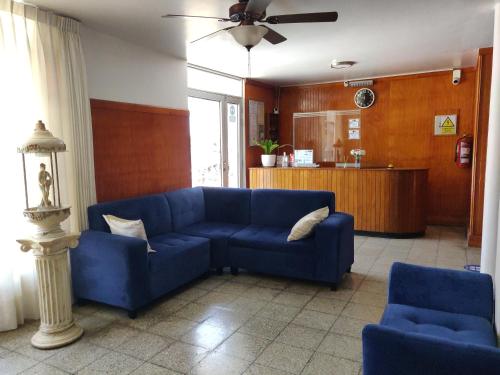 LambayequeLa Posada Norteña的客厅配有蓝色的沙发和两把椅子