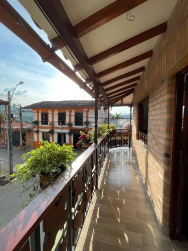 贾丁Hotel Casa Dulces del Jardín的建筑中带遮阳篷和植物的户外阳台