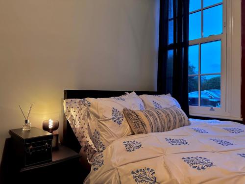 埃文河畔斯特拉特福The Bolt Hole的一间卧室配有一张带窗户的床和一张四柱床