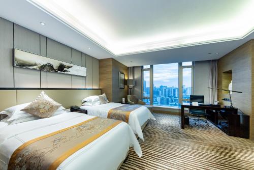 龙岗深圳雅邦朗悦国际酒店的酒店客房配有两张床和一张书桌