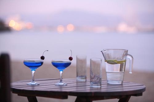 洛加拉斯帕罗酒店的一张桌子,上面有三杯眼镜和一壶蓝色的饮料