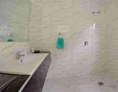 OkaihauTauhara Luxury Apartment的白色的浴室设有水槽和镜子