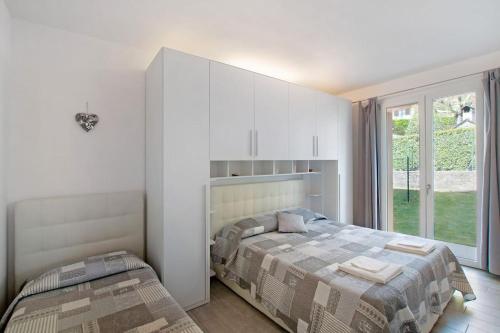 伦诺Appartamenti Zerboni的一间卧室设有两张床和大窗户