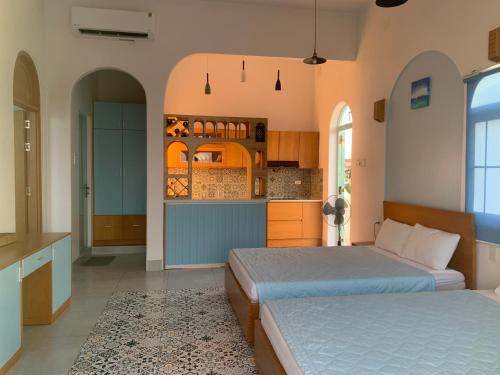 金兰Santorini Villa Cam Ranh的一间带两张床的卧室和一间厨房