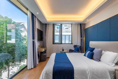 杭州杭州78号紫薇精品小院的酒店客房设有一张床和一个大窗户