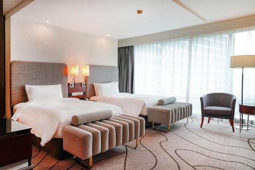 上海上海斯格威铂尔曼大酒店的酒店客房,配有两张床和椅子