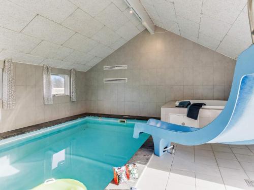 博托比14 person holiday home in Idestrup的浴室内带滑梯的游泳池