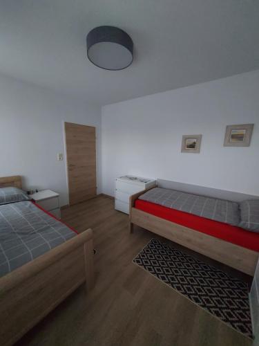 Haus Anton的一间卧室设有两张床,墙上配有一盏灯。
