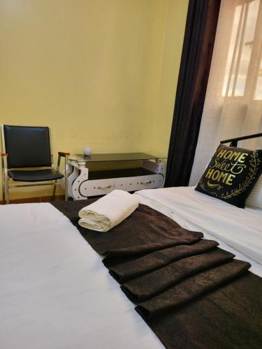 埃尔多雷特G&G Homes Eldoret的一间卧室配有一张带枕头和椅子的床