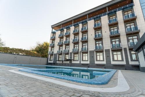 塔什干Rayyan Hotel & SPA Tashkent的大楼前设有游泳池的酒店